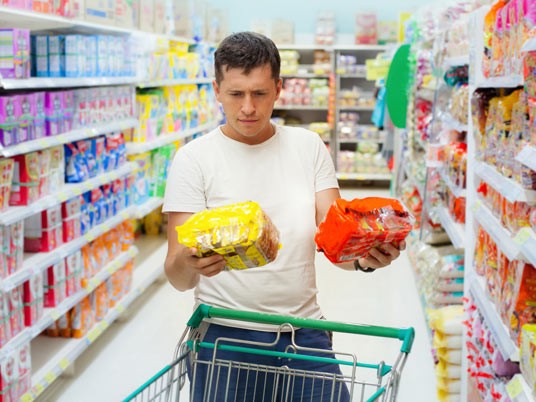 Man comparing nutritional labels